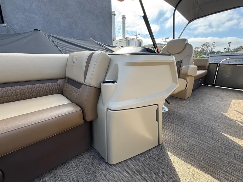 Slide: The Image of 2023 Godfrey SWEETWATER 2286 SB pontoon boat interior with beige seating and helm. - 12