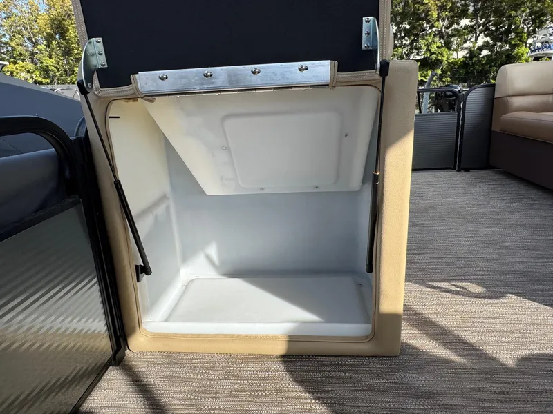 Slide: The Image of Open storage compartment on 2023 Godfrey SWEETWATER 2286 SB boat, with beige interior. - 17