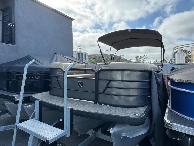 Slide: The Image of 2023 Godfrey SWEETWATER 2286 SB pontoon boat with canopy, docked outdoors. - 2