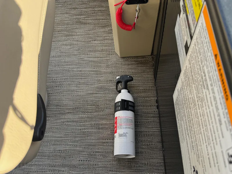 Slide: The Image of Fire extinguisher on 2023 Godfrey SWEETWATER 2286 SB boat floor, near control panel. - 26