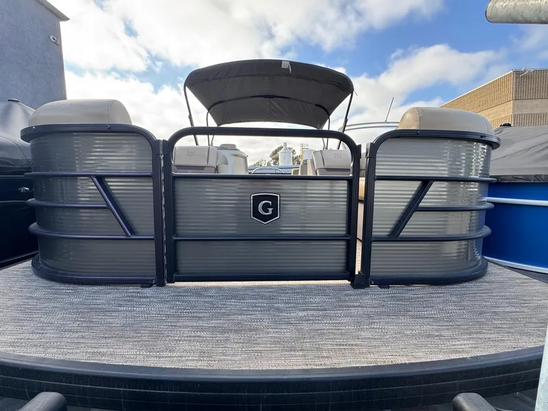 Slide: The Image of 2023 Godfrey SWEETWATER 2286 SB pontoon boat with canopy, docked under a blue sky. - 4