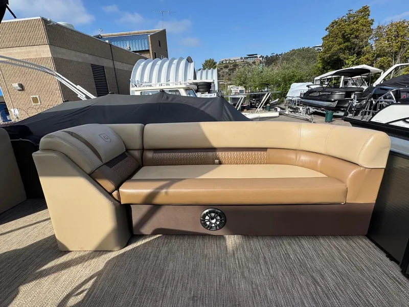 Slide: The Image of 2023 Godfrey SWEETWATER 2286 SB boat interior with beige seating and speaker. - 8