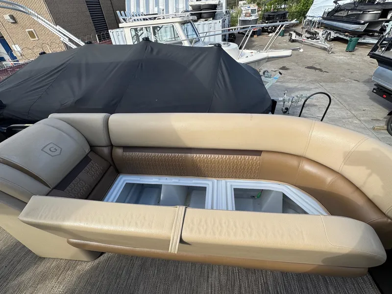 Slide: The Image of 2023 Godfrey SWEETWATER 2286 SB boat interior with beige seating and storage compartments. - 9