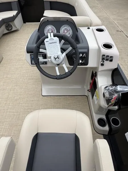 Slide: The Image of 2025 Harris Cruiser 230 boat interior with steering wheel and seating area. - 8