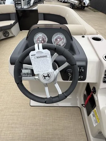Slide: The Image of 2025 Harris Cruiser 230 steering wheel and dashboard with warning label. - 9