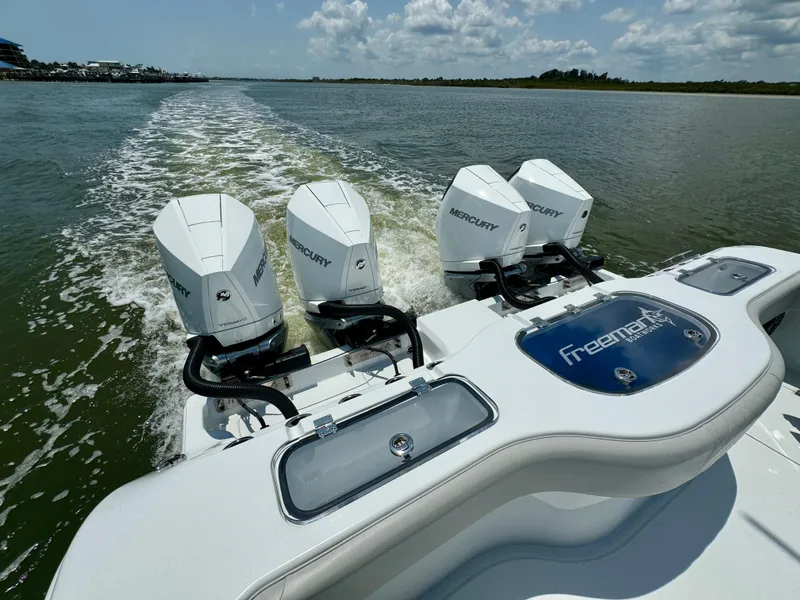 Slide: The Image of 2024 Freeman 38 boat with four Mercury engines cruising on a sunny day. - 30
