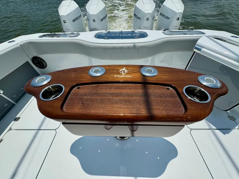 Slide: The Image of Freeman 38 boat deck with wooden table and Mercury engines, 2024 model. - 37