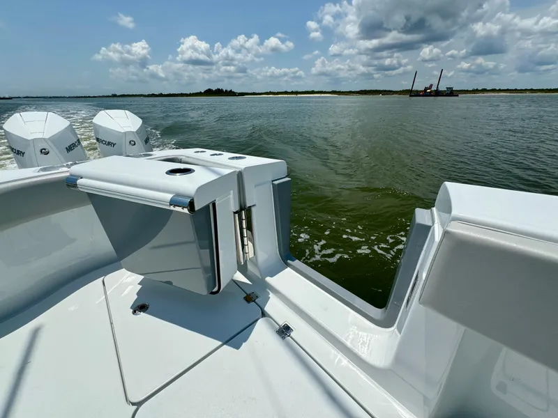 Slide: The Image of 2024 Freeman 38 boat on water, featuring dual Mercury engines, under a partly cloudy sky. - 42
