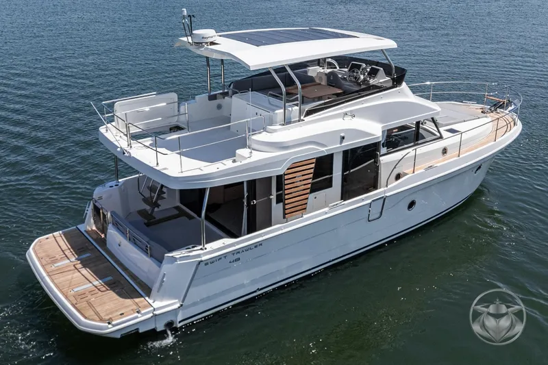 Slide: The Image of 2026 Beneteau Swift Trawler 48 cruising on calm waters, showcasing elegant design and spacious deck. - 11