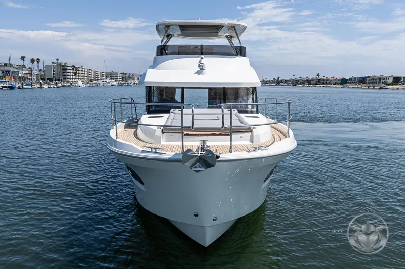 Slide: The Image of 2026 Beneteau Swift Trawler 48 on calm water, showcasing sleek design and spacious deck. - 13