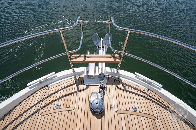 Slide: The Image of Bow view of 2026 Beneteau Swift Trawler 48 with teak deck and anchor. - 15