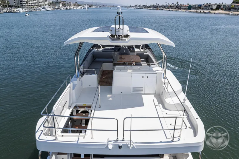 Slide: The Image of 2026 Beneteau Swift Trawler 48 cruising on a calm waterway, showcasing spacious deck. - 23