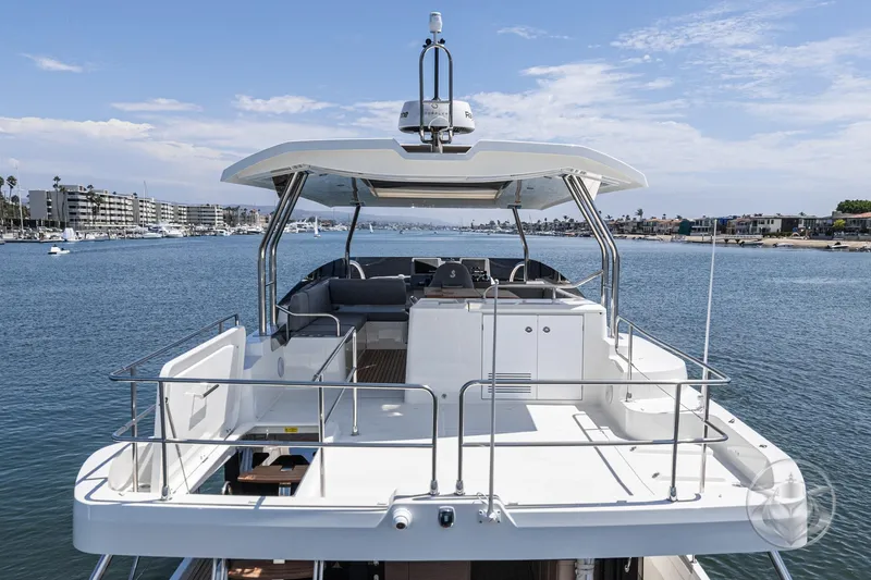 Slide: The Image of 2026 Beneteau Swift Trawler 48 on calm water, showcasing spacious deck and modern design. - 24
