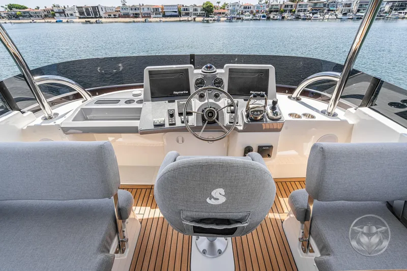 Slide: The Image of 2026 Beneteau Swift Trawler 48 helm with modern controls and waterfront view. - 26