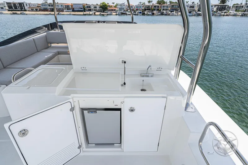 Slide: The Image of Outdoor kitchenette on 2026 Beneteau Swift Trawler 48, featuring sink and storage, dockside view. - 28