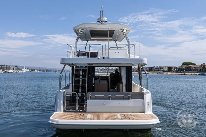 Slide: The Image of 2026 Beneteau Swift Trawler 48, rear view on water, showcasing spacious deck. - 31