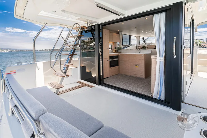 Slide: The Image of 2026 Beneteau Swift Trawler 48 interior with open deck, modern kitchen, and scenic water view. - 33