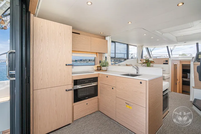 Slide: The Image of 2026 Beneteau Swift Trawler 48 interior kitchen with modern design and ocean view. - 35
