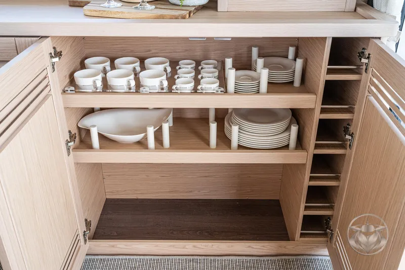 Slide: The Image of Modern kitchen cabinet with neatly organized dishes and cups on a Beneteau Swift Trawler 48, 2026. - 40