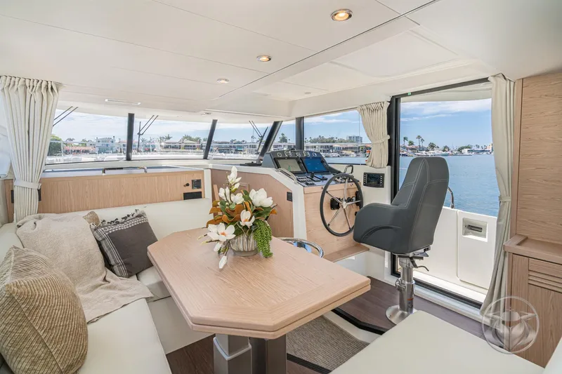 Slide: The Image of Interior of 2026 Beneteau Swift Trawler 48, featuring elegant seating and helm with waterfront view. - 5