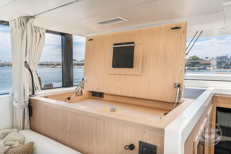 Slide: The Image of Interior of 2026 Beneteau Swift Trawler 48 with wooden storage compartment and ocean view. - 51