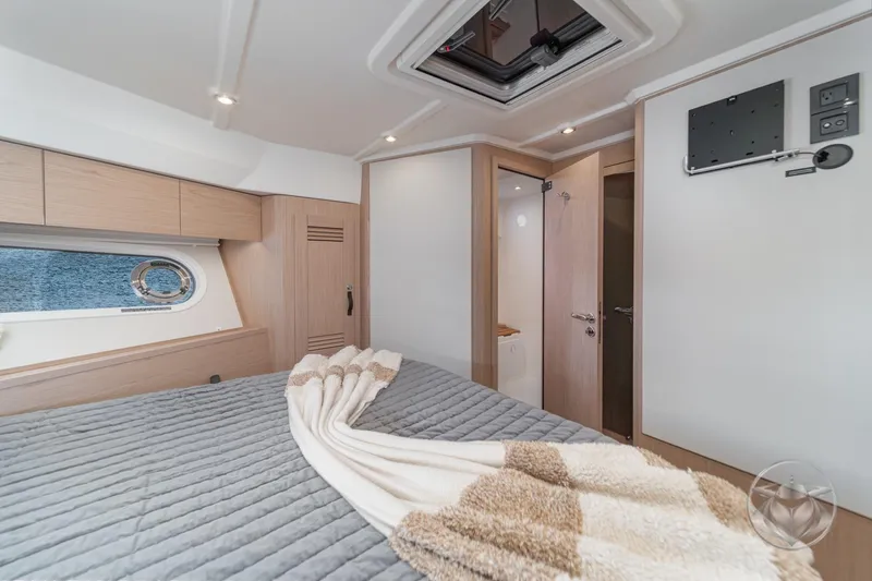 Slide: The Image of Luxurious cabin interior of 2026 Beneteau Swift Trawler 48 with modern design and cozy bedding. - 52