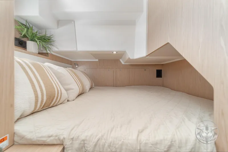 Slide: The Image of Cozy cabin interior of 2026 Beneteau Swift Trawler 48 with beige bedding and plant decor. - 56