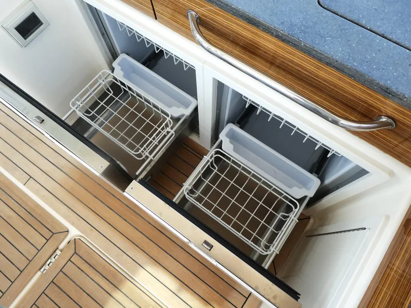 Slide: The Image of Built-in storage compartments on a 2021 Boston Whaler 405 Conquest boat with wooden flooring. - 10