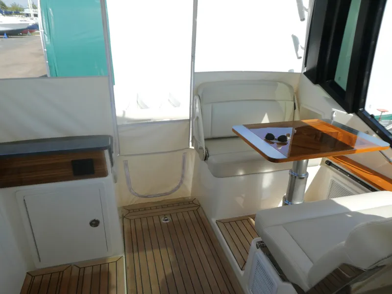 Slide: The Image of Interior of 2021 Boston Whaler 405 Conquest with seating and wooden table. - 12