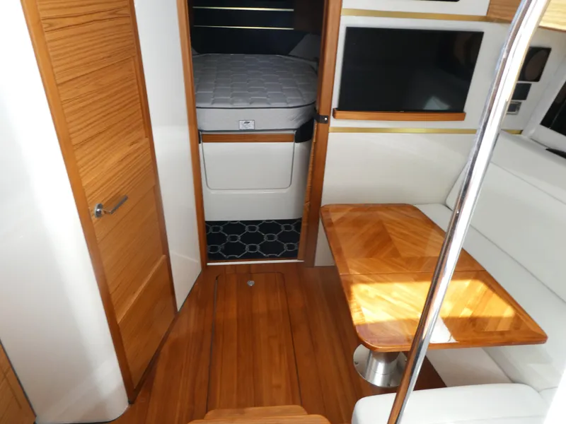 Slide: The Image of Interior of 2021 Boston Whaler 405 Conquest with wood finishes and cozy seating area. - 16
