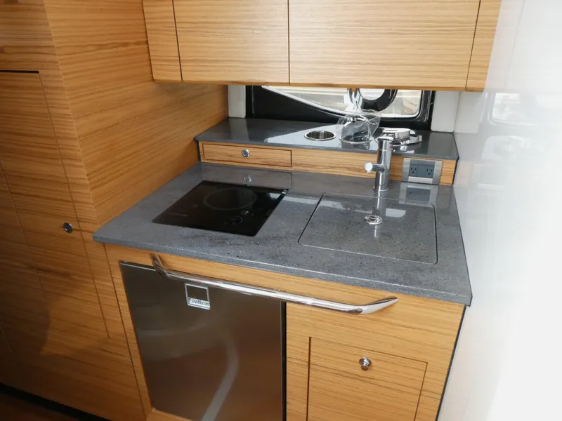 Slide: The Image of 2021 Boston Whaler 405 Conquest kitchen with modern appliances and wooden cabinetry. - 17