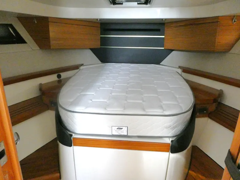 Slide: The Image of Cabin interior of 2021 Boston Whaler 405 Conquest with bed and wooden accents. - 18