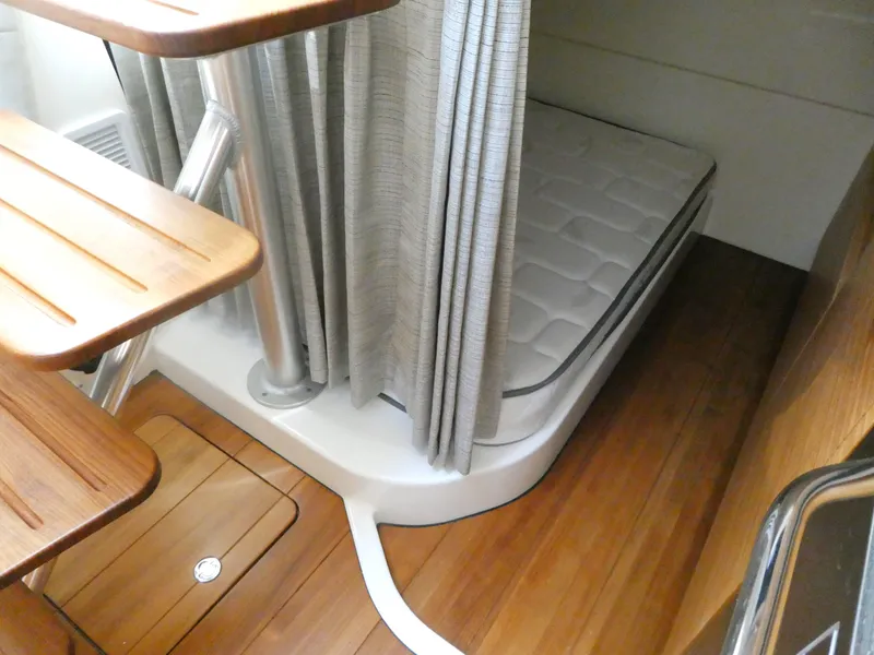 Slide: The Image of 2021 Boston Whaler 405 Conquest cabin with wooden flooring and cozy sleeping area. - 21