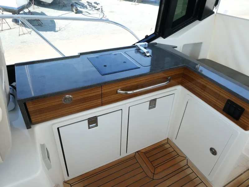 Slide: The Image of 2021 Boston Whaler 405 Conquest boat interior with sleek countertop and wooden cabinetry. - 9