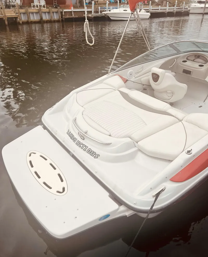 Slide: The Image of 2005 Crownline 206 LS boat docked on calm water, featuring sleek white seating and swim platform. - 4