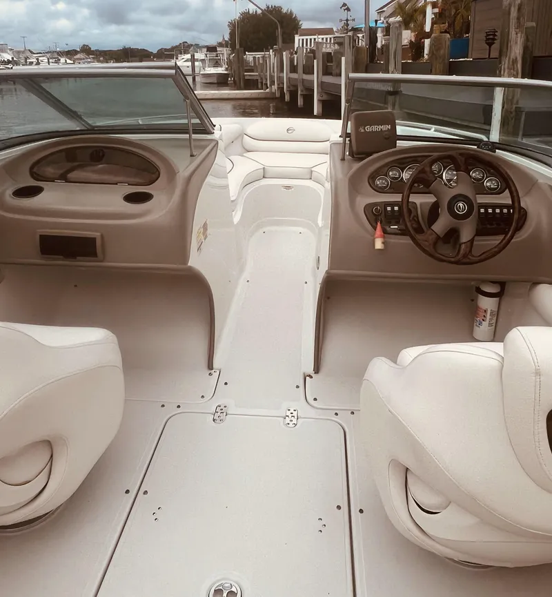 Slide: The Image of 2005 Crownline 206 LS boat interior with steering wheel and seating, docked at marina. - 5