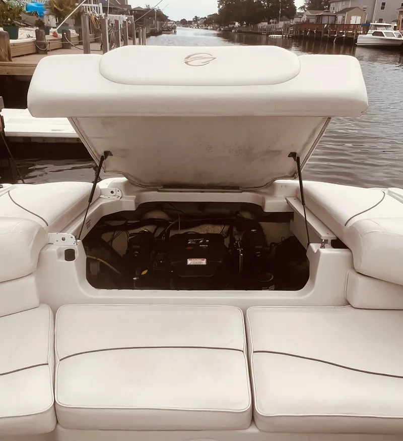 Slide: The Image of 2005 Crownline 206 LS boat with open engine compartment, docked by a serene waterfront. - 7