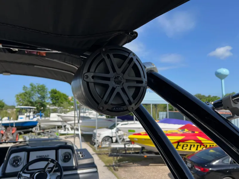 Slide: The Image of 2021 Harris FloteBote 230 Solstice boat with speaker, steering wheel, and marina background. - 10