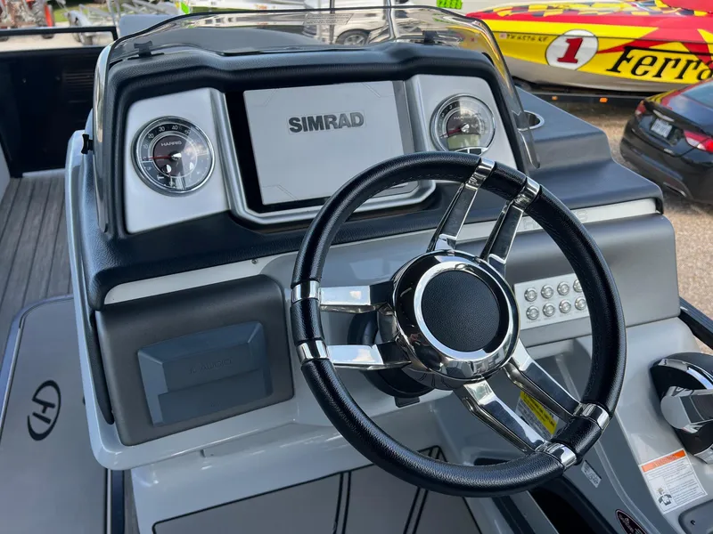 Slide: The Image of 2021 Harris FloteBote 230 Solstice helm with Simrad display and sleek steering wheel. - 18