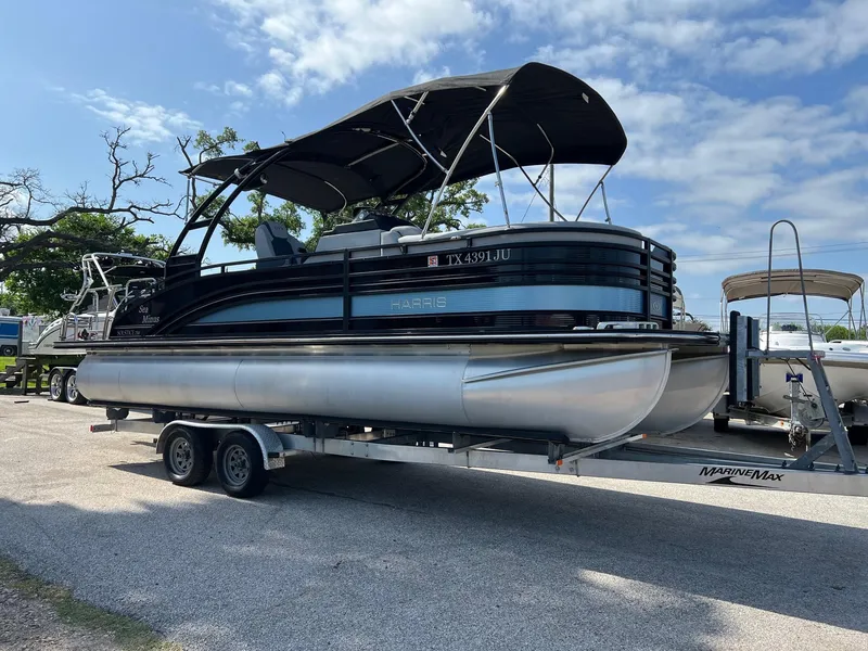 Slide: The Image of 2021 Harris FloteBote 230 Solstice pontoon boat on trailer under blue sky. - 3