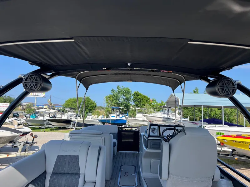 Slide: The Image of 2021 Harris FloteBote 230 Solstice interior with canopy, docked among other boats. - 8