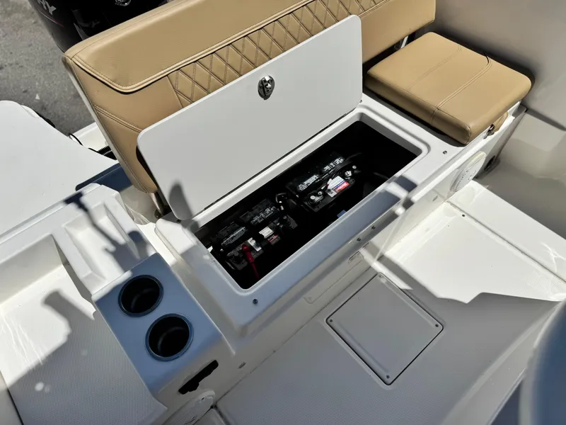 Slide: The Image of 2023 Bayliner Trophy T20CC boat battery compartment with seating and cup holders. - 16
