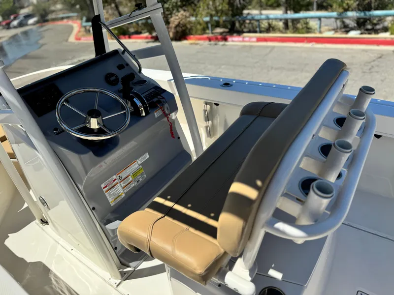 Slide: The Image of 2023 Bayliner Trophy T20CC boat interior with steering wheel and seating area. - 20
