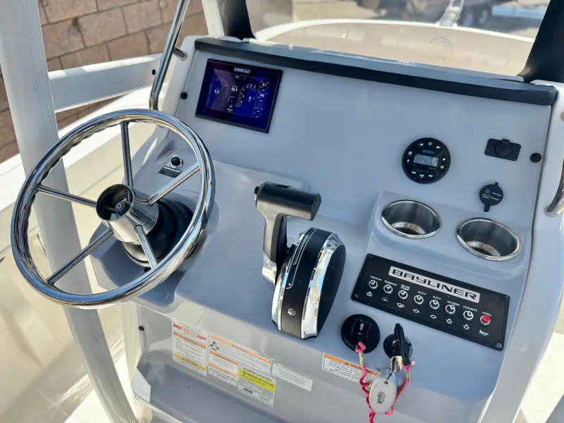 Slide: The Image of 2023 Bayliner Trophy T20CC boat dashboard with steering wheel and control panel. - 22