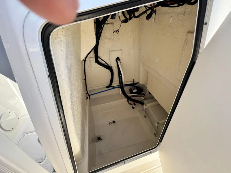 Slide: The Image of 2023 Bayliner Trophy T20CC storage compartment with visible wiring and clean interior. - 25