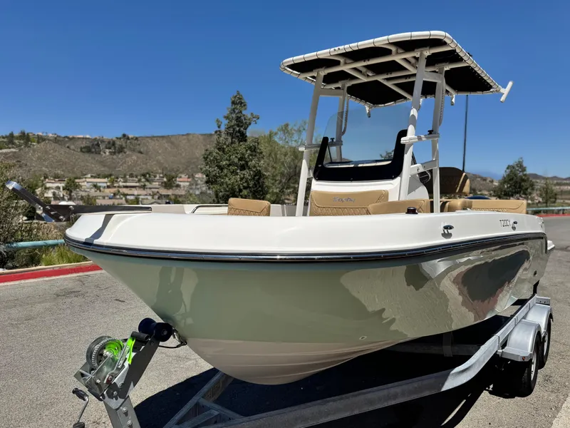 Slide: The Image of 2023 Bayliner Trophy T20CC boat on trailer, parked outdoors under clear blue sky. - 3