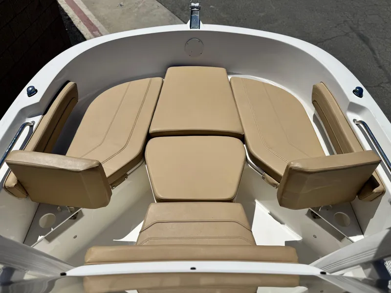 Slide: The Image of 2023 Bayliner Trophy T20CC boat interior with beige cushioned seating. - 7