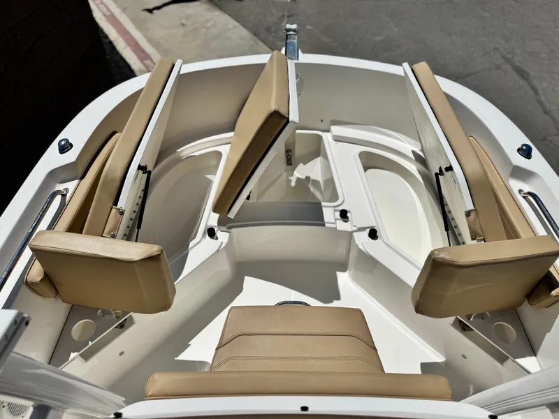 Slide: The Image of 2023 Bayliner Trophy T20CC boat interior with tan seating and storage compartments. - 8
