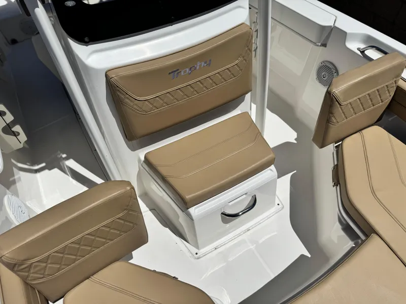 Slide: The Image of 2023 Bayliner Trophy T20CC boat interior with tan cushioned seating and storage. - 9