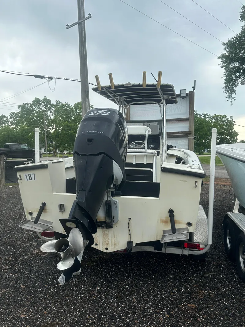 Slide: The Image of 1985 SeaCraft 23 CC boat with outboard motor, parked on gravel, overcast sky. - 10